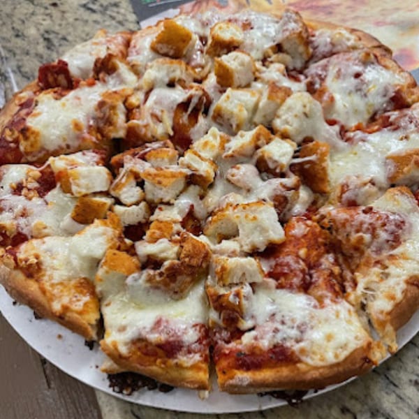 A Pinellas Pizzeria pizza with tomato sauce, melted cheese, and crouton-like toppings.
